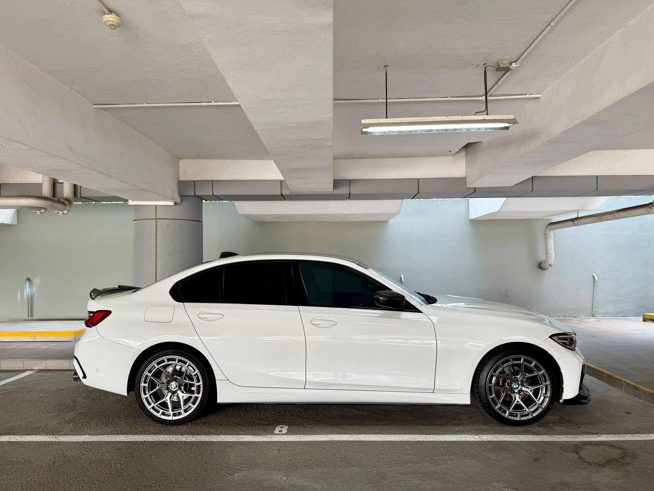 White BMW 316i sedan, side profile, parked in a garage